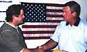 photo of Rep. Simpson shaking hands with a constituent in front of an American flag
